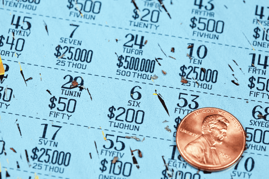 a lottery scratch-off ticket fully scratched with a shiny US penny