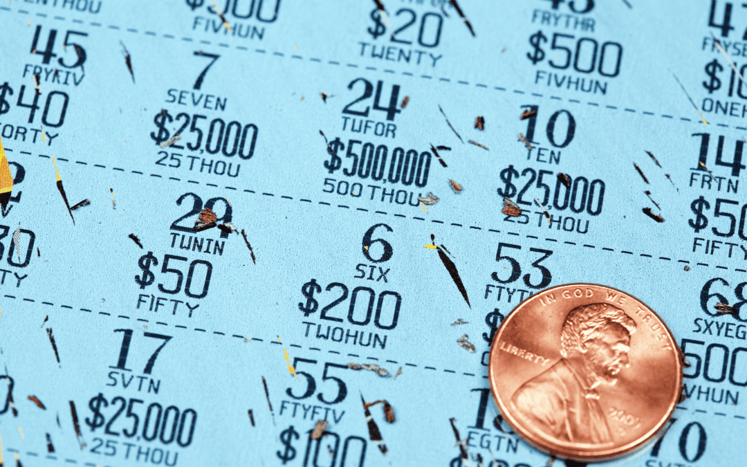 a lottery scratch-off ticket fully scratched with a shiny US penny