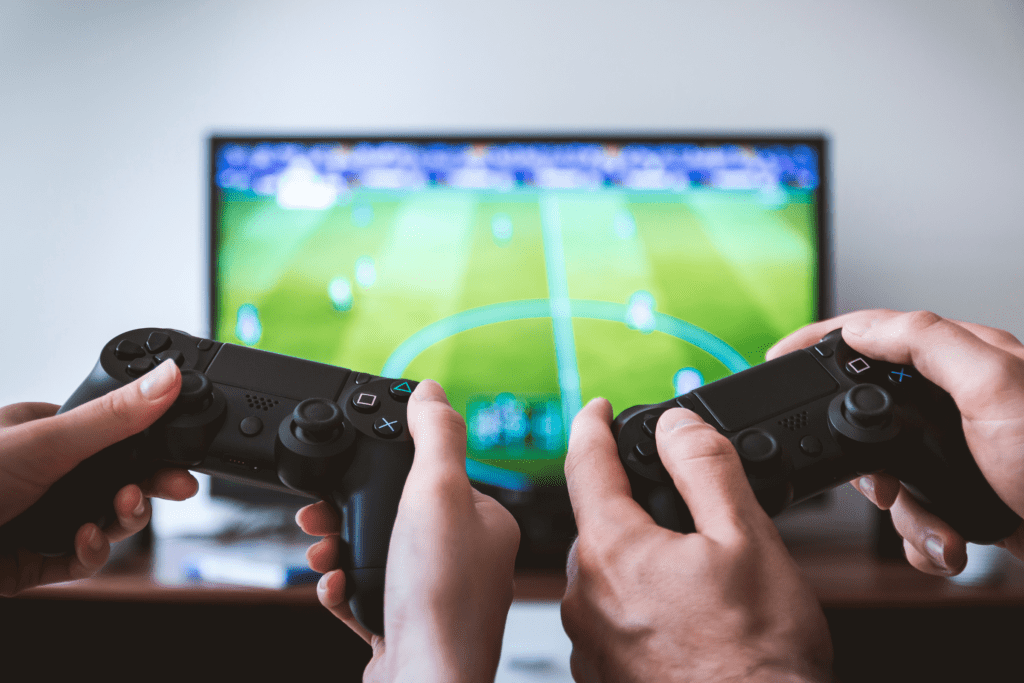 two sets of hands play a sports video game